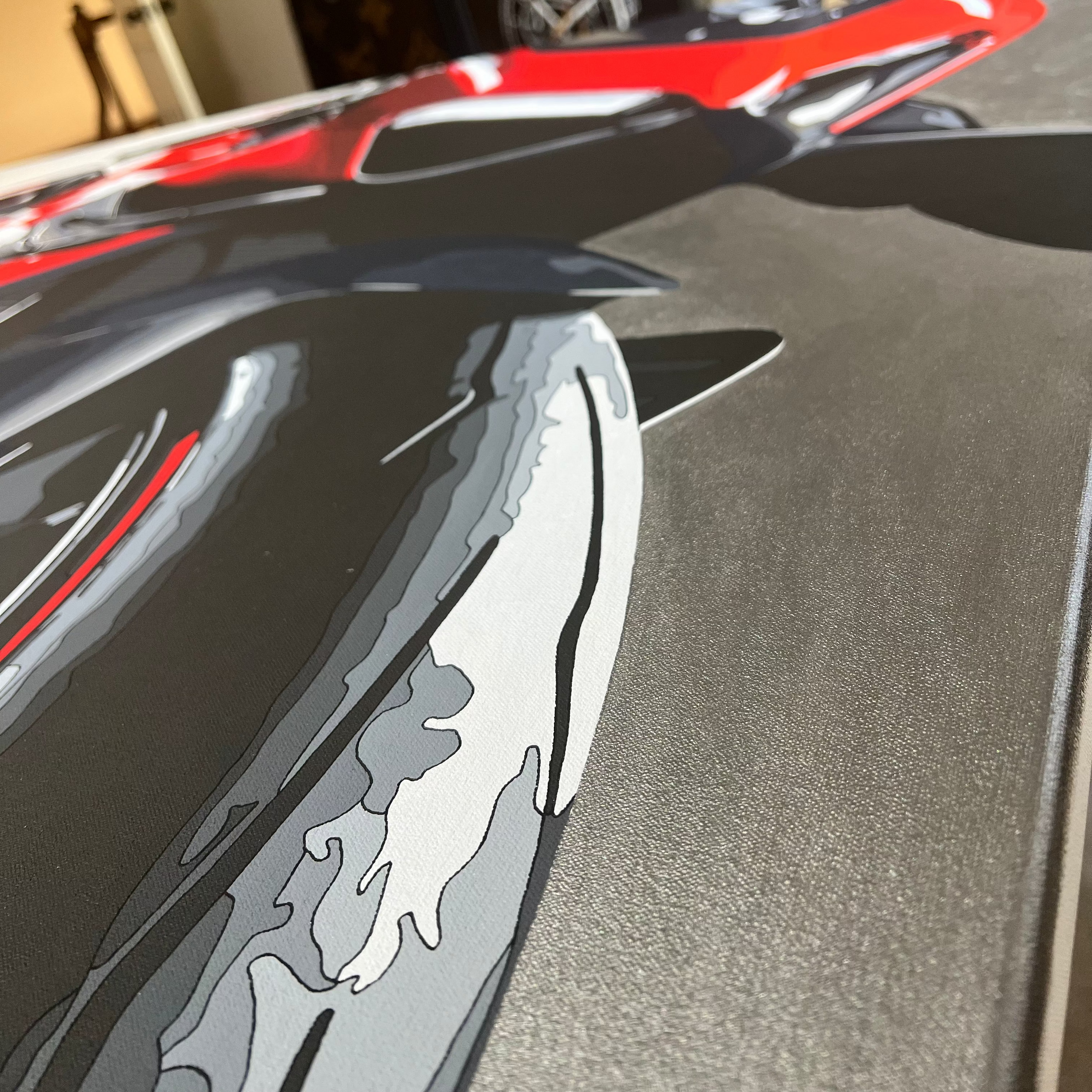 Close-up of a car's rear wing with a flame design, blurred background