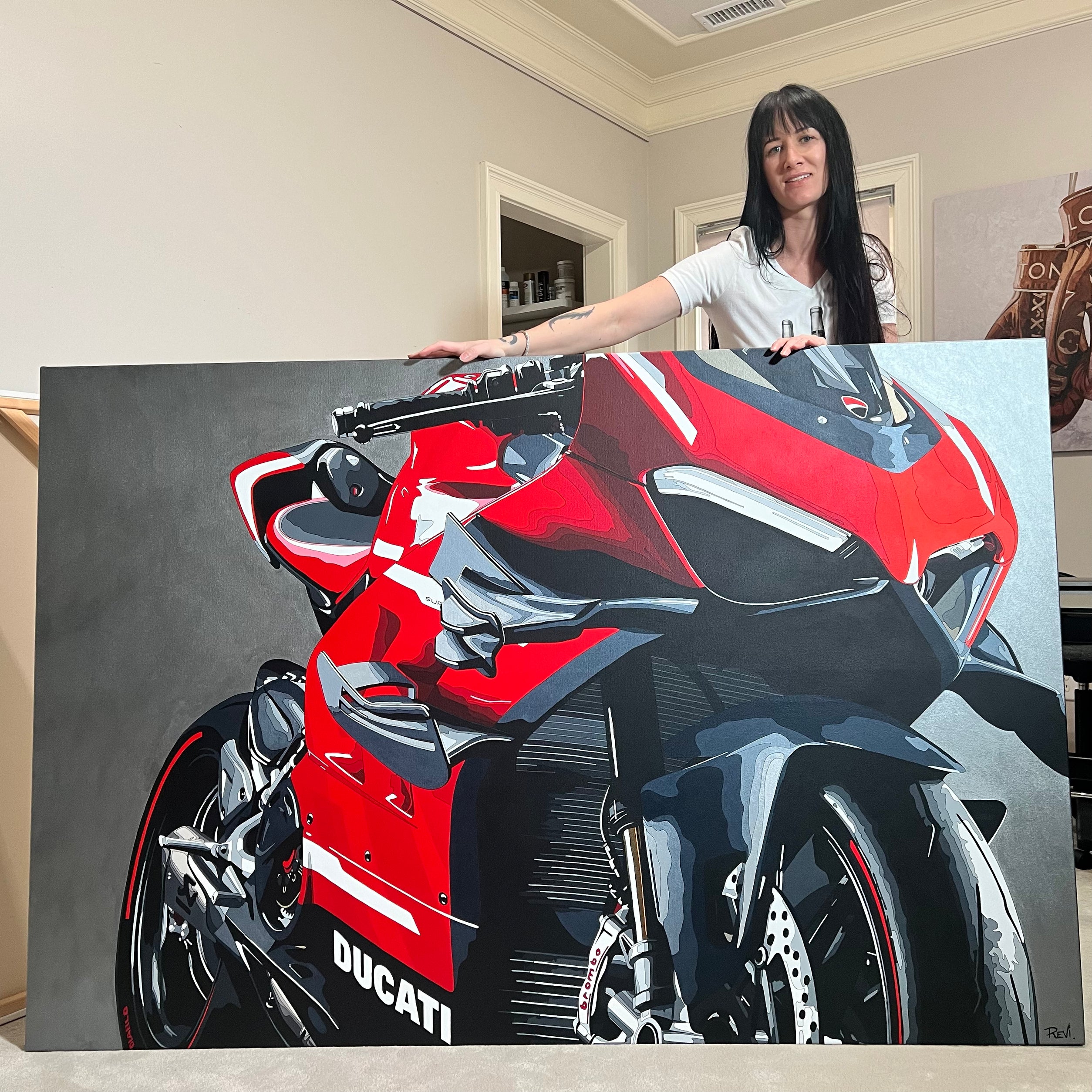 Woman holding a painting of a red Ducati motorcycle