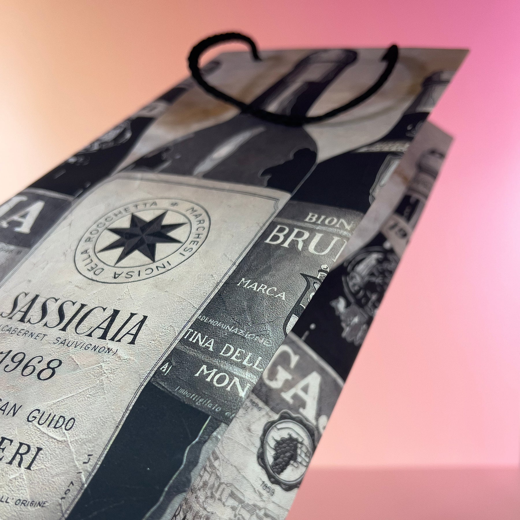 Close-up of a wine bottle wine gift bag on a pink gradient background.