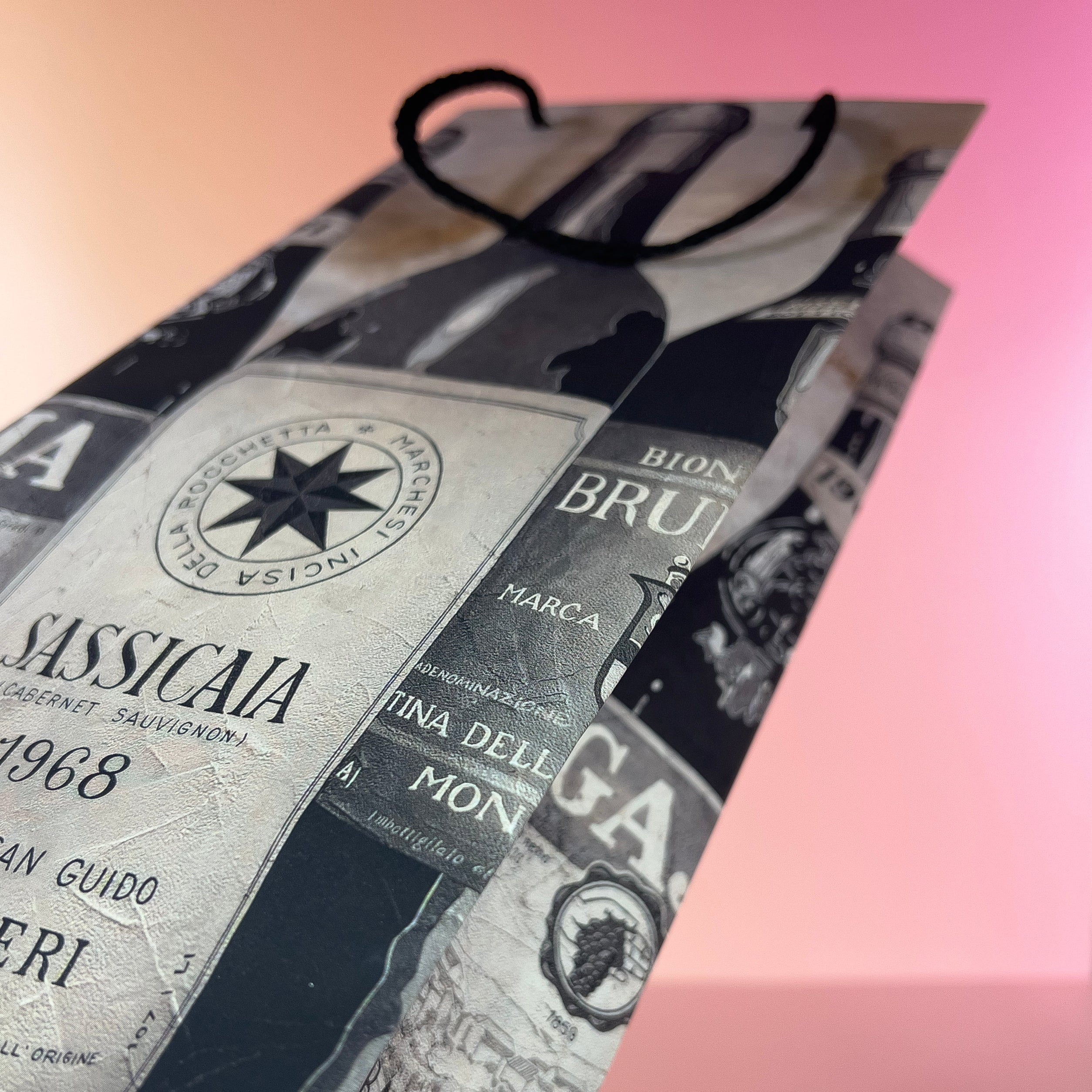 Close-up of a wine bottle wine gift bag on a pink gradient background.